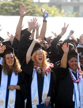 Commencement candidates in caps and gowns cheering