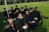 Emeriti professors seated under a canopy during commencement ceremonies