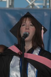 Graduate Amy Elizabeth Caldwell sings the national anthem during commencement ceremonies