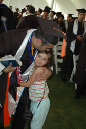 A graduate embraces a young family member