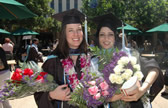 Graduates pose with flower bouquets received after commencement