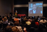 President Milton A. Gordon and conference participants watching CSU Chancellor Charles Reed on a projection screen