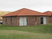 Multi-unit single-story brick buildings amid lawns of manicured grass.