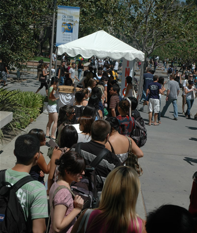 A sea of students wait in line to pick up student planners at the information booths on campus.
