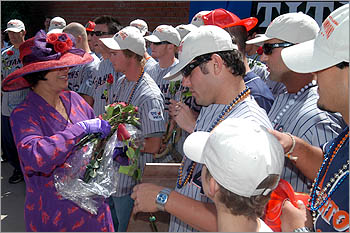 A member of the Red Hat Society give honorary roses to the team.