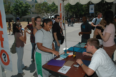 Service with a smile. Bobby Jacques, right, provides information to history major Ragina Perry at the information booth located next to McCarthy Hall.