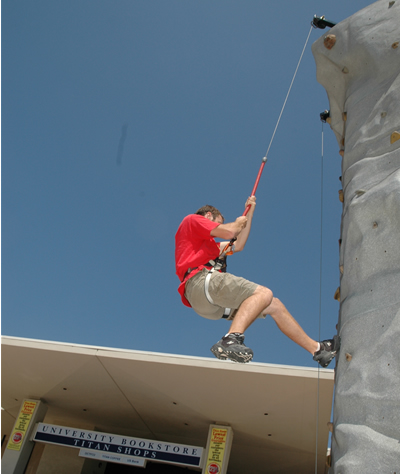 Isaac Shirley, an undeclared major, makes his descent from the rock wall during Rec Fest festivities Thursday, Aug. 23. Students, faculty and staff members could also participate in group exercises classes, games and demonstrations during the annual health and fitness information fair sponsored by Associated Students&rsquo; Recreation Sports program.