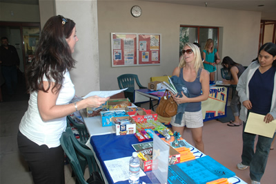 Serena Cline of New Student Programs, left, finds information being sought by liberal studies major Megan Radcliff during the Cal State Fullerton Irvine Campus &ldquo;Snack Attack&rdquo; on Aug. 22. 